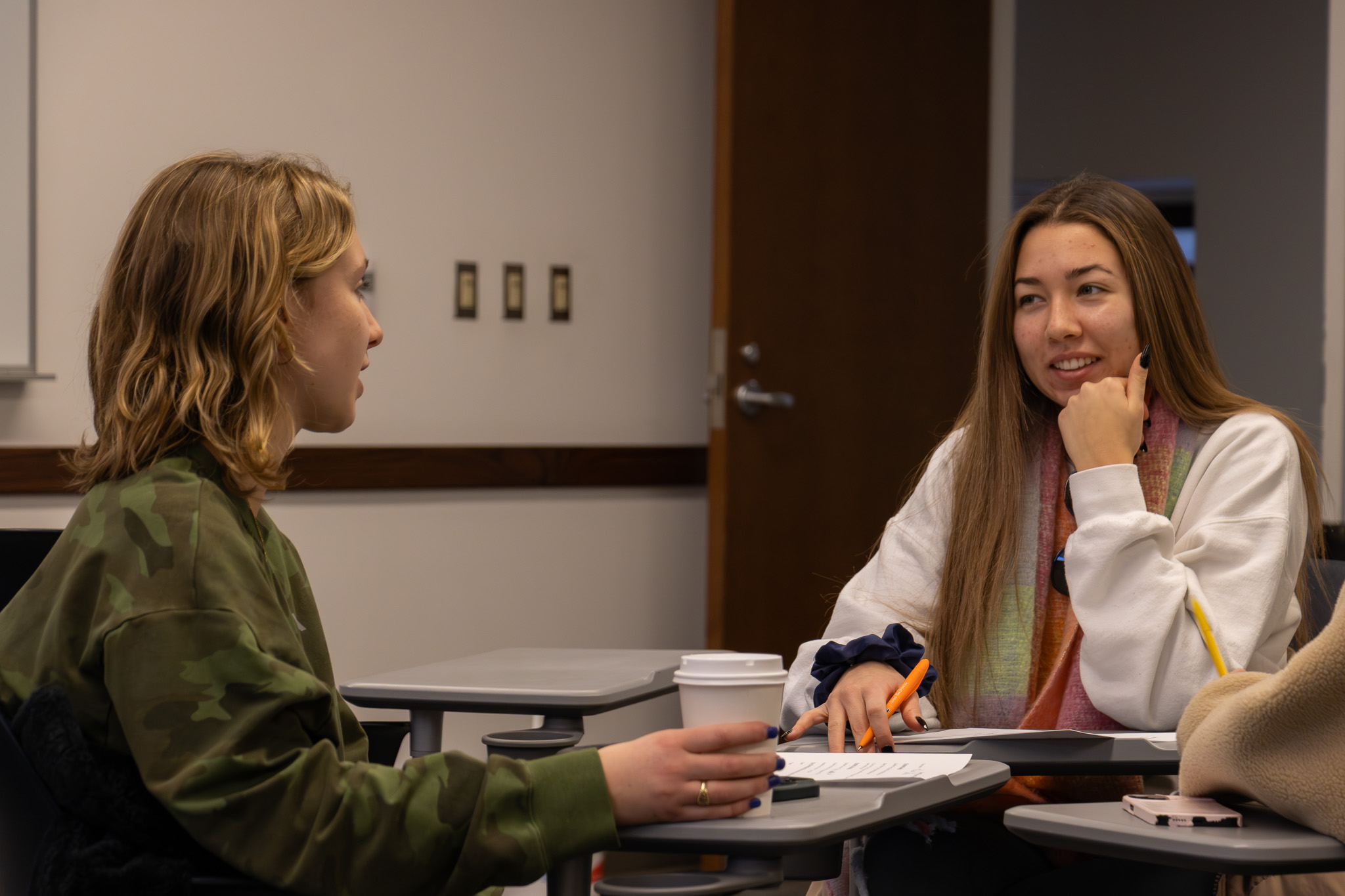 students have a conversation in a classroom