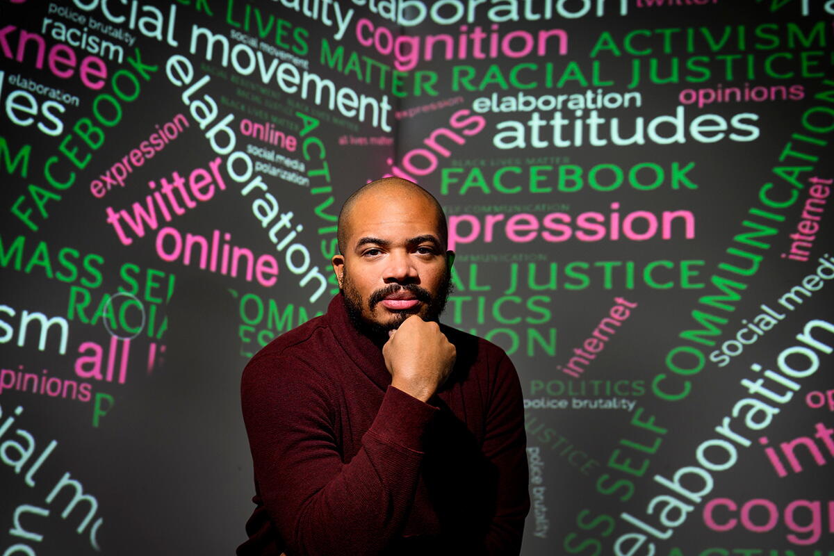 Professor Stewart Coles posing in front of a word cloud