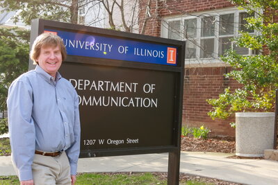 Dale Brashers standing in front of the sign for the Department of Communication