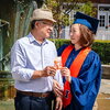 Max and Bonnie Kim holding a photo of Max's graduation
