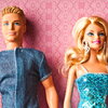 A Ken and Barbie doll, placed in front of a pink background