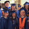 Professor John Lammers poses with a group of graduates in regalia