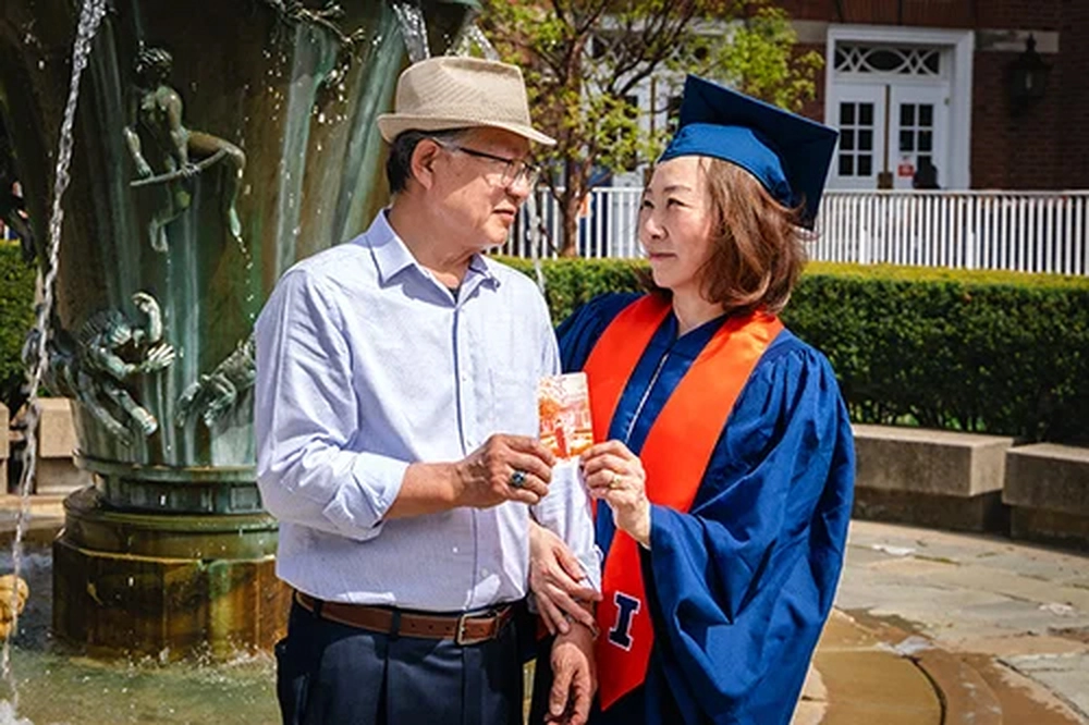 Max and Bonnie Kim holding a photo of Max's graduation