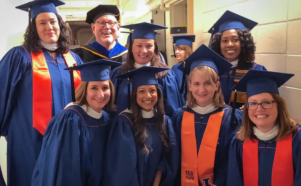 Professor John Lammers poses with a group of graduates in regalia
