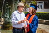 Max and Bonnie Kim holding a photo of Max's graduation