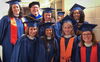 Professor John Lammers poses with a group of graduates in regalia