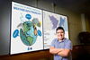 Joseph Trujillo-Falcon standing in front of a screen displaying study graphics